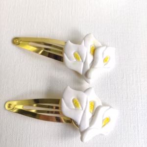 Gancho dourado com flores de jarro branco e centro amarelo, feito à mão.