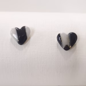Brincos em forma de coração, em preto e branco com apontamentos dourados, feitos à mão, com acabamento brilhante